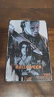 Metal sign showing Halloween movie characters and title.