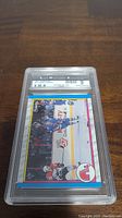 Front face of the Joe Sakic rookie hockey card graded 9 by SMA inside a plastic protective slab showing the on-ice action and branding details.