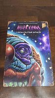 Front view of a colorful large movie poster showing alien clown artwork and title against starry space background, measuring about 8x12 inches