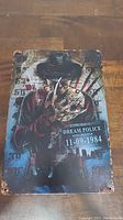 Photo of metal wall art showing Freddy Krueger from Nightmare on Elm Street with police arrest placard dated 11-09-1984