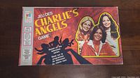 Top view of the Charlie's Angels game box with colorful illustrations featuring the three main characters from the TV show and branding in English and French.
