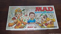 Top side of the MAD Magazine board game box with colorful cartoon characters and logo.