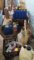 Overview of car care lot with multiple blue bottles of oil, plastic fuel/oil jugs, and spray cans