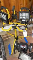 Photo showing the Pro Tech heavy duty bench grinder and the WorkForce dual lights on yellow tripod stand in basement setting.
