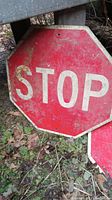 Stop sign showing scratches, peeling paint, cracks, and dirt on octagonal red and white surface