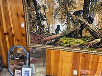 Photo of bear themed tapestry hanging on wood paneled wall with two mirrors on the floor below