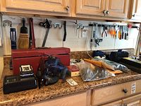 Kobalt cordless saw charger and saw on countertop next to red toolbox and other tools