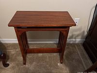 Front view of the wooden flip-top table showing rectangular top and four legs with curved edges.