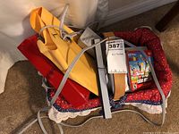 Nintendo Wii console with cables, sensor bar, and game cases visible in basket.