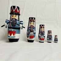 Front view of five drummer nesting dolls arranged in descending size from left to right, showing detailed facial paint and drum major hats.