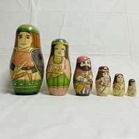 Front view of the 6 Russian nesting dolls depicting explorers and historical characters lined up in descending size.
