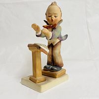 Side angled view of the Goebel Hummel Band Leader figurine showing the boy conducting with music stand in front.