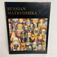 Front cover of the hardcover book titled "Russian Matryoshka" with a colorful image of nesting dolls and gold text on black background.
