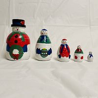 Frontal view of the five snowman nesting dolls arranged from largest to smallest.