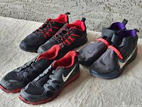 Three pairs of Nike sneakers displayed on a beige surface showing overall condition and exterior design.