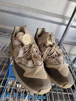 Pair of Nike Air Huarache sneakers in desert camo, showing overall wear and state of the shoes.