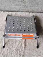 Top view of the aluminum work platform showing perforated surface and brand label.