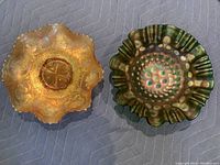 Top view of two carnival glass bowls, orange with Dragon & Lotus pattern and green with Stippled Coin Dot pattern.