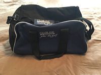 Front view of navy blue Club Links duffel bag with black handles and white piping.