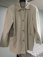 Front view of beige ladies spring coat by Nuage, showing button closure and pockets.