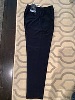 Navy blue women's pants laid flat showing full length and taper, original tags attached.