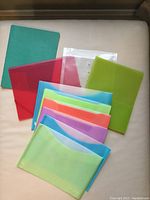 First photo showing assortment of plastic and cardboard report covers in various colors and shapes