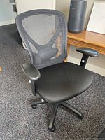 Front angle view of one chair showing mesh back, fabric seat, armrests, and wheel base.