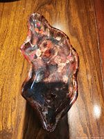 Top view photo of a unique ceramic ash tray showing its irregular organic shape with wavy edges and multicolor glaze finish.