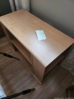 Angle view of one light wood side table showing the rectangular top and open shelf below. Light wood grain and smooth finish visible.