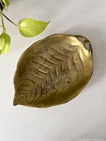 Top down view showing the leaf details, patina, and overall shape of the brass tray