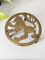 Top view showing round brass stand top with lion cutout design.