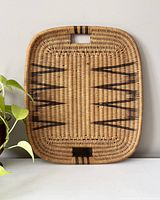 Top-down photo of the rectangular wicker serving tray showing the woven pattern and built-in cutout handles.