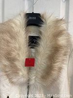 Close-up front photo showing removable beige-tinted faux fur collar and blouse hanger.