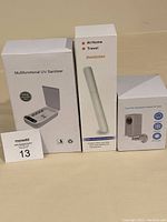 Three boxed items: multifunctional UV sanitizer box, handheld UV light sterilizer, transparent waterproof case box.