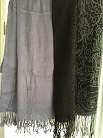 Mauve and black pashmina scarves hanging side by side showing color, fabric, and pattern details