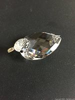 Photo showing the full crystal duck figurine on a black background, highlighting its faceted body, clear crystal material, and silver beak.