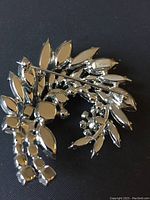 Back of the brooch showing the pin mechanism and Sherman signature mark on silver-tone metal base