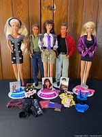 Front view showing all five dolls with stands, clothes, accessories