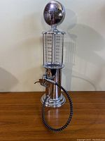 Full front view of the vintage Bar Butler liquor dispenser shaped like a gas pump with measurement markings and dispensing hose.