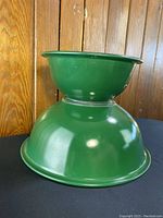 Side view of two green Pyrex nesting bowls, showing green exterior and clear glass bottom