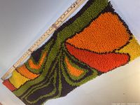 Partial view of the rug next to a ruler showing the height and thickness approximately 14" tall and 1" thick.