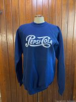 Full view of navy blue sweatshirt showing front with Pepsi-Cola logo.
