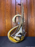 Front view of handblown glass swan showing marbled green, white, amber glass and curved neck.