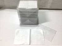 Stacked and shrink-wrapped set of 100 white microfiber cleaning cloths with one cloth and one clear pouch placed in front to show item and packaging.