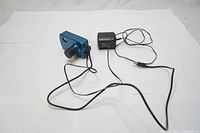 Blue 1080P HD webcam with lens and power adapter showing full connected setup on white background