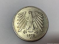 Close-up of the coin's obverse side showing the federal eagle above the date 1975 with the letter 'F' mintmark.