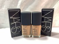Two bottles of NARS Sheer Glow foundation in Syracuse shade with their black NARS boxes.