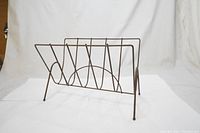Side view of metal V shaped record holder with four legs and circular wire accents.