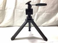 Image showing the tripod standing unfolded with legs extended and mount with handle visible.