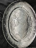 View of the entire oval glass platter showing the embossed leaf and berry botanical design.